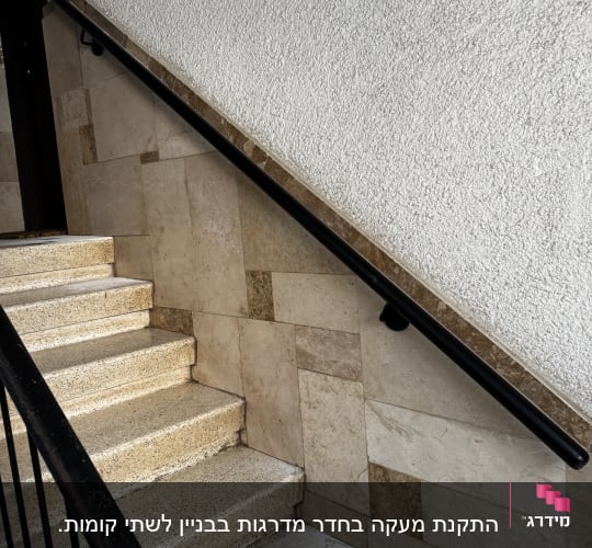 מעקה מתכת שחור על מדרגות אבן